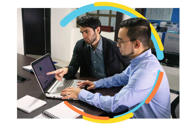 Foto de dos jóvenes empresario sentados en un escritorio revisando que con la herramienta EDN su empresa puede agilizar el diseño, creación y promoción de la gestión empresarial de su empresa o negocio.